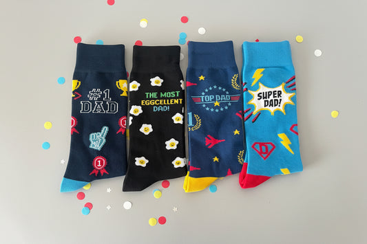 Four pairs of colorful socks with father's day text and graphics 