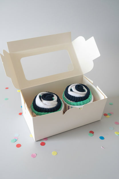 Two pairs of striped socks in a white box on a black surface